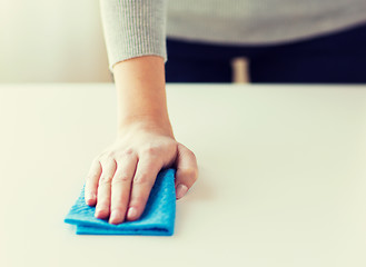 Image showing close up of woman cleaning table with cloth