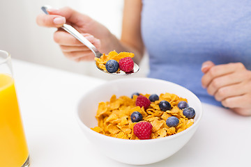 Image showing close up of woman eating corn flakes for breakfast