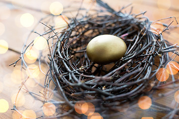 Image showing close up of golden easter egg in nest on wood