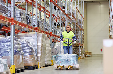 Image showing man carrying loader with goods at warehouse