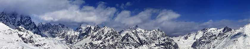 Image showing Large panoramic view on snowy mountains in haze at sunny day