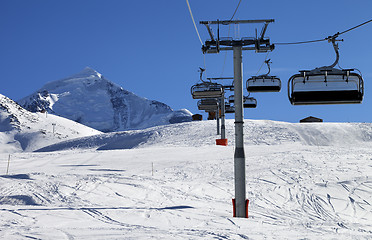 Image showing Chair lift in snowy mountains at nice sunny day