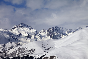Image showing Snowy off-piste slope and mountains in clouds
