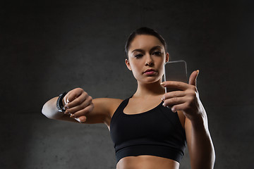 Image showing woman with heart-rate watch and smartphone in gym