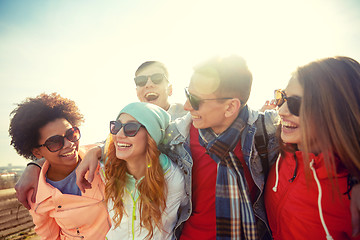 Image showing smiling friends in sunglasses laughing on street