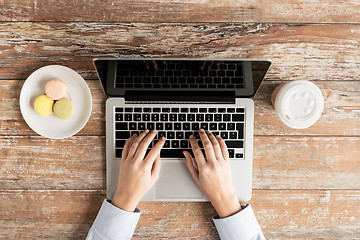 Image showing close up of female hands with laptop and coffee