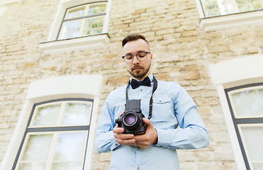 Image showing happy young hipster man with film camera in city