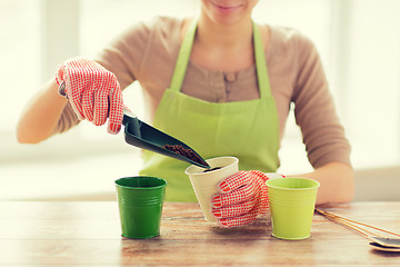 Image showing close up of woman hands with trowel sowing seeds