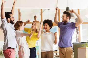 Image showing happy creative team celebrating victory in office