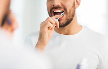 Image showing close up of man with toothbrush cleaning teeth