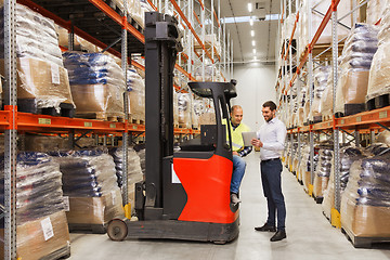 Image showing men with tablet pc and forklift at warehouse