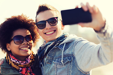 Image showing happy teenage friends in shades taking selfie