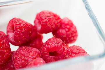 Image showing close up of ripe red raspberries in glass