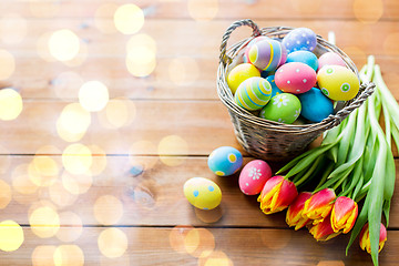 Image showing close up of easter eggs in basket and flowers