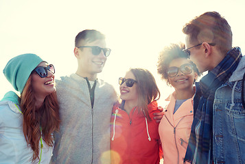 Image showing happy teenage friends in shades talking on street