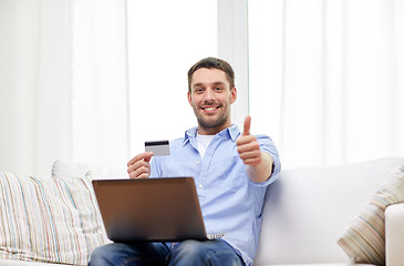 Image showing man with laptop and credit card showing thumbs up