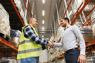 Image showing worker and businessmen with clipboard at warehouse