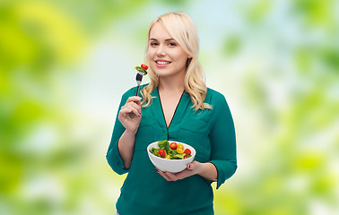 Image showing smiling young woman eating vegetable salad
