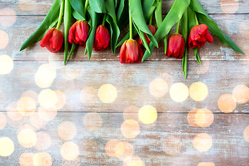 Image showing close up of red tulips on wooden background