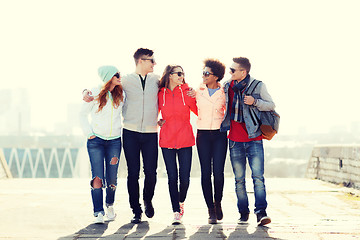 Image showing happy teenage friends walking along city street