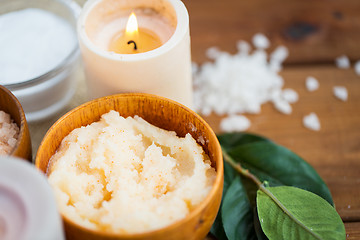 Image showing close up of natural body scrub and candle on wood