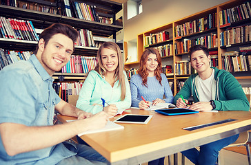 Image showing happy students writing to notebooks in library