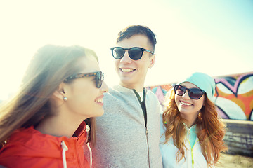 Image showing happy teenage friends in shades talking on street