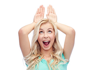 Image showing happy smiling young woman making bunny ears