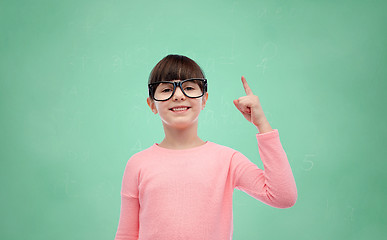 Image showing happy little girl in eyeglasses pointing finger up