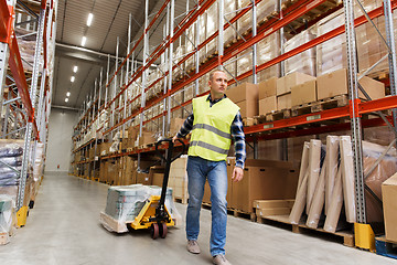 Image showing man carrying loader with goods at warehouse