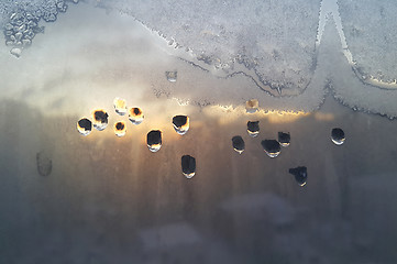 Image showing Water drops, ice pattern and sunlight on window glass