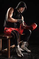 Image showing The young  man kickboxing lacing glove