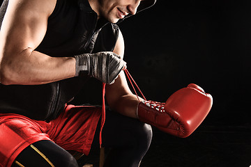 Image showing The young  man kickboxing lacing glove