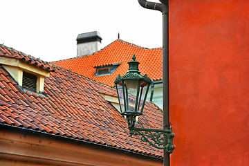 Image showing Traditional street lamp and the tiled roofs of Prague