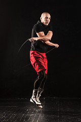 Image showing The legs of muscular man with skipping rope