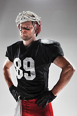 Image showing American football player posing with ball on white background