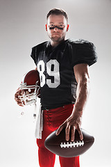 Image showing American football player posing with ball on white background