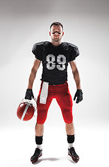 Image showing American football player posing with ball on white background