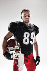 Image showing American football player posing with ball on white background