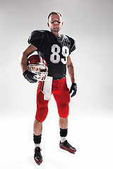 Image showing American football player posing with ball on white background