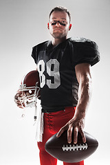 Image showing American football player posing with ball on white background