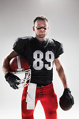 Image showing American football player posing with ball on white background