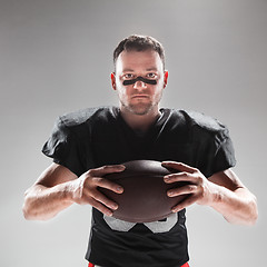 Image showing American football player posing with ball on white background