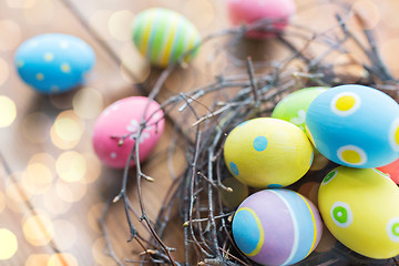 Image showing close up of colored easter eggs in nest on wood