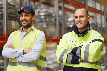 Image showing smiling men in reflective uniform at warehouse