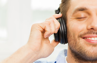 Image showing smiling young man in headphones at home