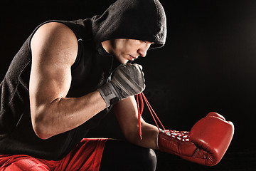 Image showing The young  man kickboxing lacing glove