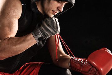 Image showing The young  man kickboxing lacing glove