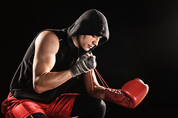 Image showing The young  man kickboxing lacing glove