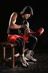 Image showing The young  man kickboxing lacing glove